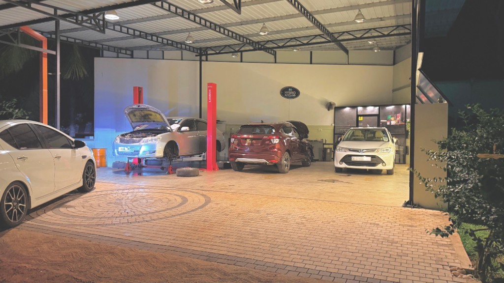 Hybrid Autoland service bay at night with Hybrid Autoland signage and vehicles in the workshop