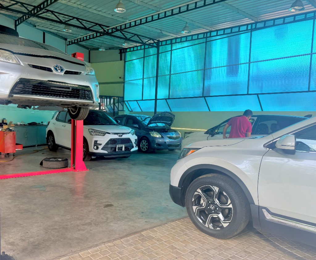 Hybrid Autoland workshop interior with hybrid vehicles on the lift and bright service bays