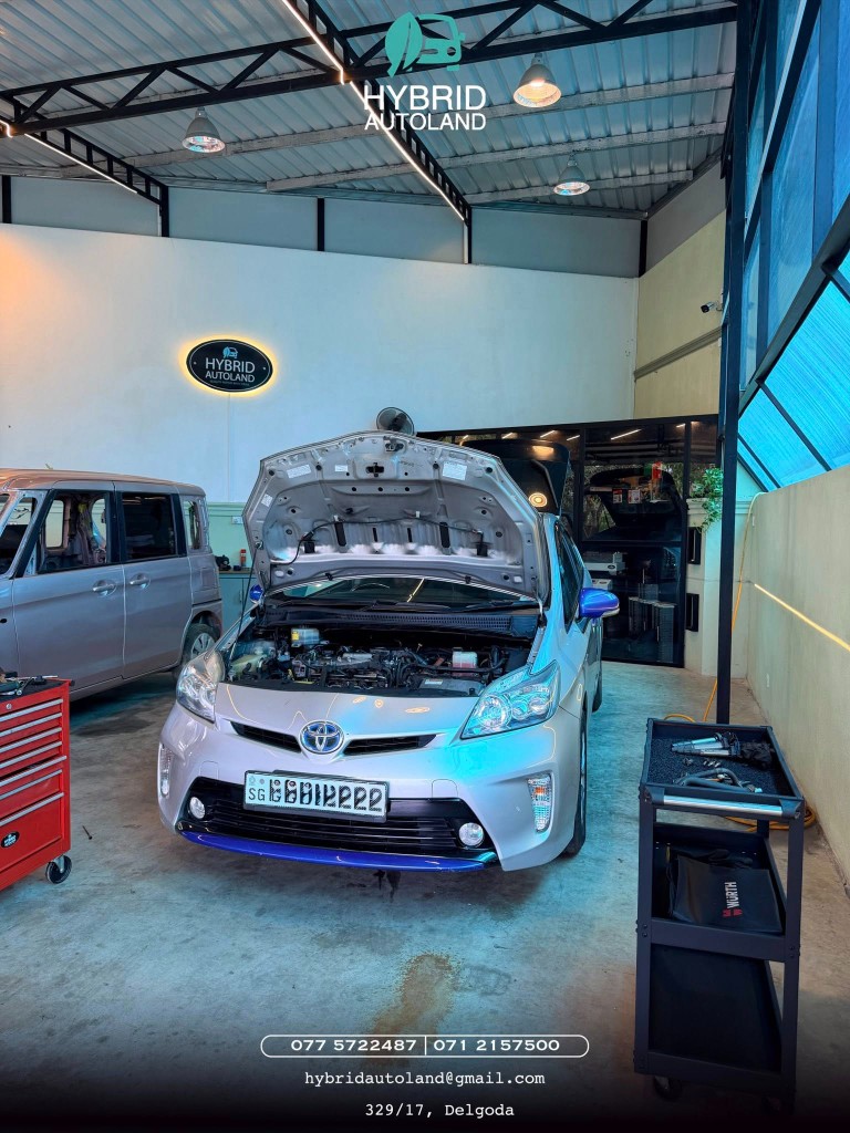 Silver Toyota Prius with hood open in the workshop