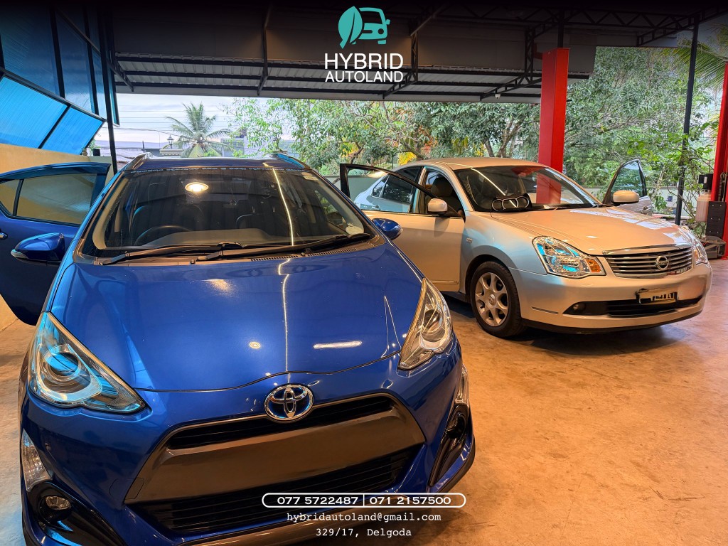 Blue Toyota Aqua and silver Nissan sedan under the workshop canopy