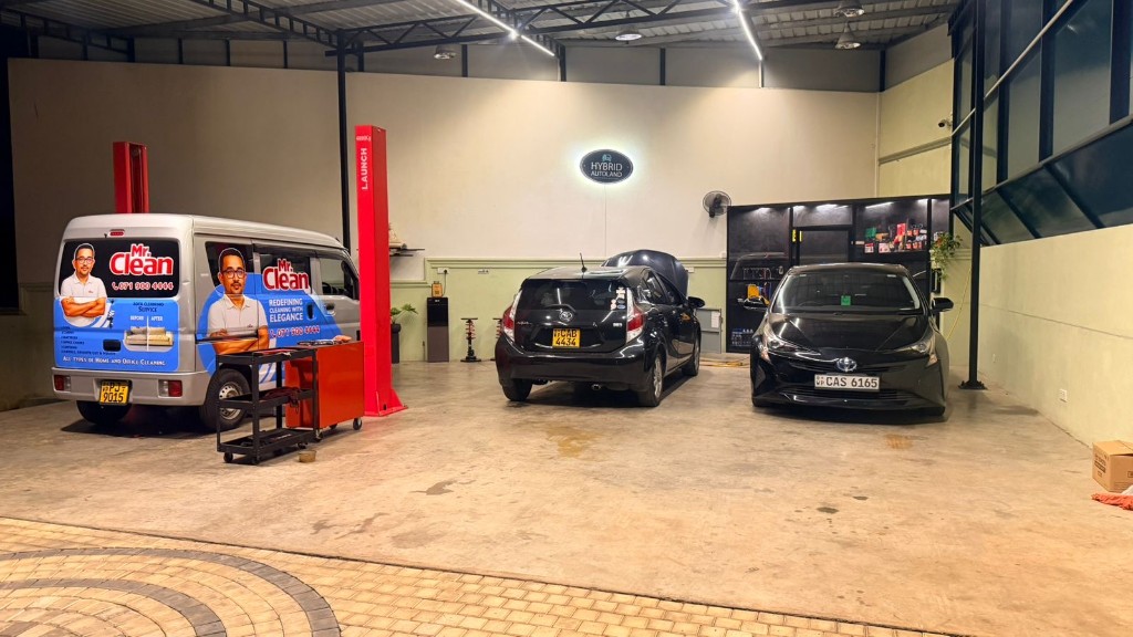 Hybrid Autoland workshop interior with lifts, vehicles in service bays, and wall signage